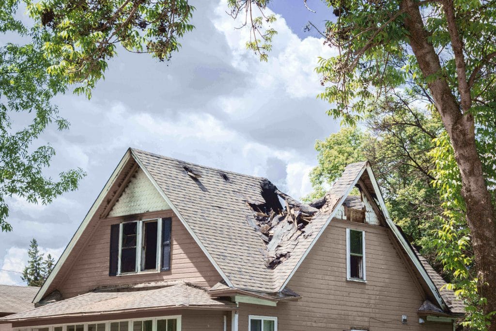 picture of home with roof damage from storm